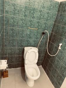 桑给巴尔Sanaa Hostel的绿色瓷砖墙内带卫生间的浴室