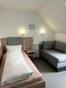 阿尔腾斯塔特加尼伊莱特酒店 的一间带床和沙发的小卧室