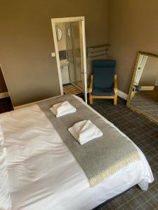 波特帕特里克No 4 Portpatrick B&B的一间卧室配有一张带镜子和蓝椅的床