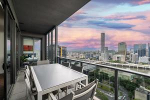 布里斯班Multi Million River View 3BD Penthouse at SouthBank的市景阳台配有桌椅。