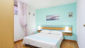 玛丽娜迪曼卡维萨Villetta Ischia by Salento Affitti的卧室配有白色的床和蓝色的墙壁