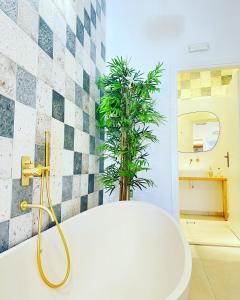 阿斯提帕莱亚镇Gerani Deluxe Houses的一间带浴缸的浴室,里面装有植物