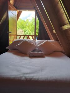 圣奥古斯丁Cabañas Amalú的一张带枕头的床和一个帐篷内的窗户