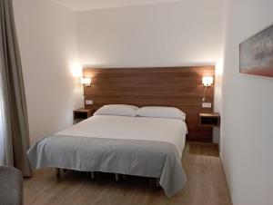 阿莱奥尔ROMANDRE的卧室配有一张白色大床和木制床头板