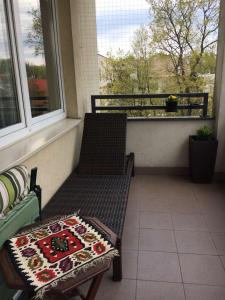 克拉科夫Apartament Alutka的阳台设有长凳、桌子和窗户。