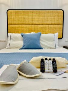 阿斯提帕莱亚镇Gerani Deluxe Houses的一张带两个枕头的床和三瓶