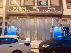达赫拉Dakhla sky blue的停在阿达卡天空蓝色建筑前的白色汽车