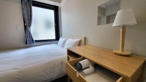 东京Ueno Woo Hotel的一间卧室配有一张床和一张带台灯的桌子