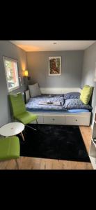 德累斯顿Tiny-Ferienwohnung Hellerau 2的一间小卧室,配有一张床和一把绿色椅子