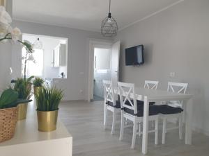 圣彼得罗镇Mare e Vacanze的白色的用餐室配有白色的桌椅