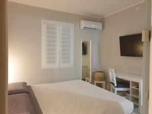 圣彼得罗镇Mare e Vacanze的一间卧室配有一张床、一张书桌和一台电视
