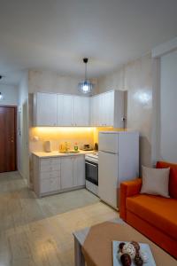 卡利斯托斯Central House Karistos的厨房配有白色橱柜和橙色沙发