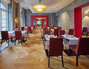 康斯坦茨Hotel Alte Post的用餐室配有桌子和红色椅子