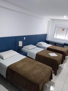 阿雷格里港HOTEL ECONOMICO - 150m Santa Casa, Prox Assembleia e UFRGS的一间设有三张床和蓝色墙壁的房间