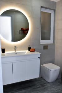 纳杜尔Golden Rays Apartment的一间带水槽、镜子和卫生间的浴室
