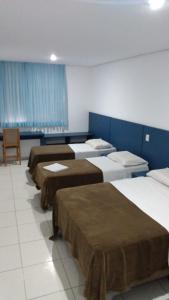 阿雷格里港HOTEL ECONOMICO - 150m Santa Casa, Prox Assembleia e UFRGS的蓝色墙壁的房间的一排床位