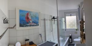 伍珀塔尔Ankommen WOHLFüHLEN in kompletter Wohnung 2 Schlafzimmer FREi Parken TOP Anbindung A46 NETFLIX的浴室墙上挂着帆船的画作