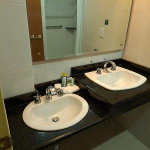 托卢卡Howard Johnson by Wyndham Toluca的一间带两个盥洗盆和大镜子的浴室