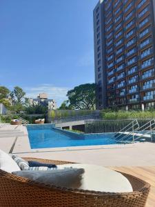 阿雷格里港MyHome - Suíte de Luxo próximo ao Shopping Iguatemi e Consulado Americano的一座大型游泳池,其建筑背景为: