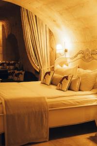 乌奇希萨尔Vigor Cappadocia - Special Class的卧室配有带窗帘的白色床