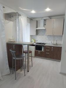 尼古拉耶夫Lux apartment Sadovaya street的厨房配有白色橱柜和桌椅