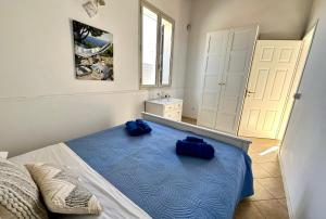 阿沃拉Il Frantoio di Avola的一间卧室配有一张带两个蓝色枕头的床