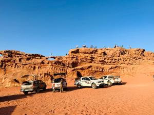 瓦迪拉姆Wadi Rum Oryx Hostel & Tours的停在沙漠中的一群车辆