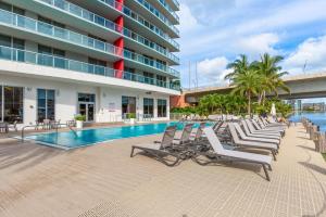 好莱坞Panoramic views 1 bed Beach Walk 27th Miami的游泳池旁的一排躺椅