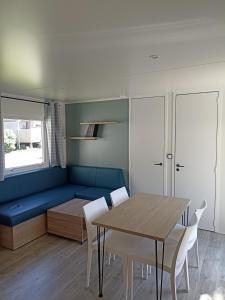 盖朗德Le panorama的一间配备有蓝色沙发和一张桌子的用餐室