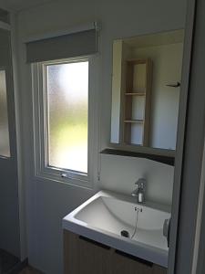 盖朗德Le panorama的一间带白色水槽和窗户的浴室