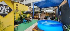 桑托斯Quintal da Bella Hostel的一座带大型蓝色浴缸的庭院