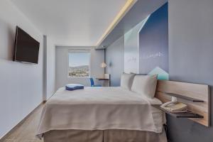 马萨特兰One Mazatlán的一间卧室配有一张大床和一台平面电视