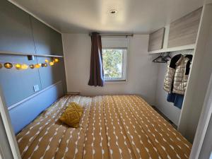 卢米奥Mobilhomme LECCI 3 CHAMBRES AVEC VUE MER EXCEPTIONNELLE的一间小房间,卧室内配有一张床