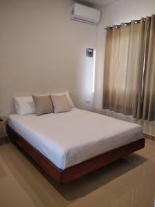 巴卡拉尔Apartamento的一间卧室配有一张带白色床单的床和一扇窗户。