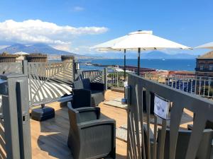 那不勒斯B&B Musica e Mare的一个带椅子和遮阳伞的阳台,并享有海景。