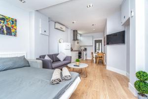 伦敦Modern Apartment in East London的一间卧室配有一张床、一张沙发和一张桌子