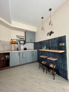 利沃夫Апартаменти Underground&SPA的厨房配有蓝色橱柜和2个酒吧凳