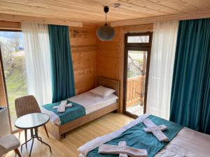 KhuloHotel Khulo lnn的一间卧室配有两张带横跨横跨的床铺。
