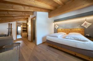 萨姆瑙恩Aparthotel Grischuna的一间卧室配有一张大床和木制床头板