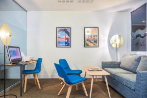 佩皮尼昂Holiday Inn Perpignan, an IHG Hotel的客厅配有蓝色椅子和沙发