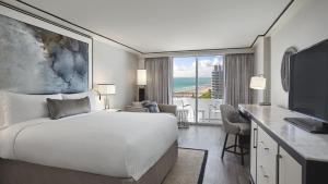 迈阿密海滩洛伊斯迈阿密海滩酒店 的一间卧室配有一张床和一张书桌及电视