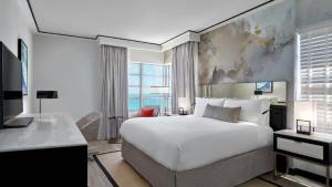 迈阿密海滩洛伊斯迈阿密海滩酒店 的一间卧室配有一张床、一张书桌和一台电视