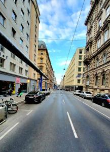 维也纳The Vast Core的一条空荡荡荡的城市街道,有停放的汽车和建筑物