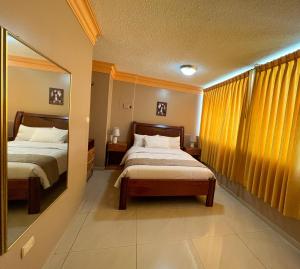 曼塔Apart Hotel Hamilton的酒店客房,设有两张床和镜子