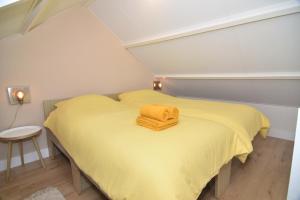海边的艾格蒙特Casa Feliz的一间小卧室,配有黄色的床和黄色的毯子
