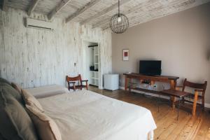 GualeguaychúPosada Las Aguas的一间卧室配有一张床、一张书桌和一台电视。