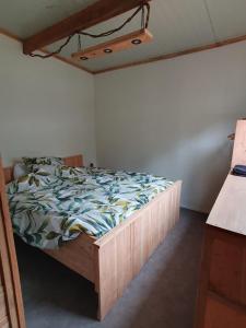 WehlNatuurchalet de Das的一间卧室配有一张木架床