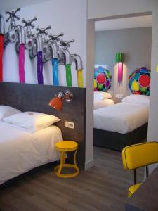 维耶尔宗威尔森宜必思尚品酒店的酒店客房的墙上设有两张带遮阳伞的床。