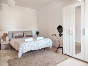 阿罗纳La casita的白色卧室配有床和镜子