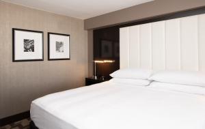 洛杉矶贝弗利山万豪酒店的一间卧室配有一张白色的大床和两张框图